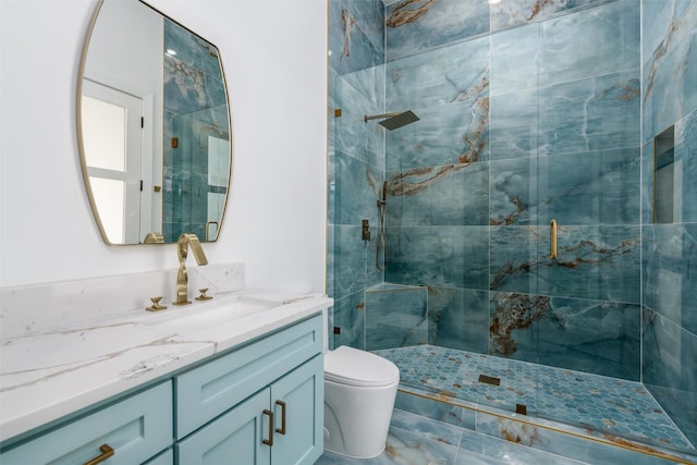 bathroom with vanity, a shower stall, and toilet