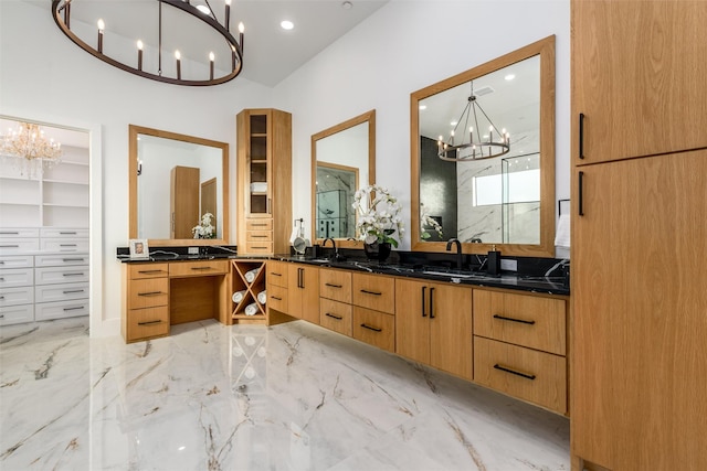 full bathroom with double vanity, a marble finish shower, marble finish floor, and a chandelier