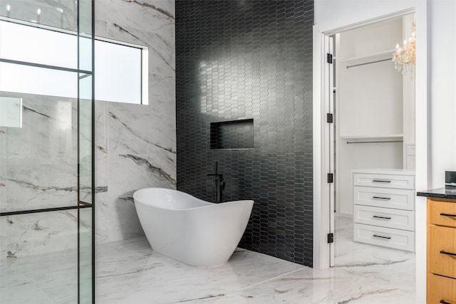 full bathroom featuring marble finish floor, a marble finish shower, and a freestanding bath