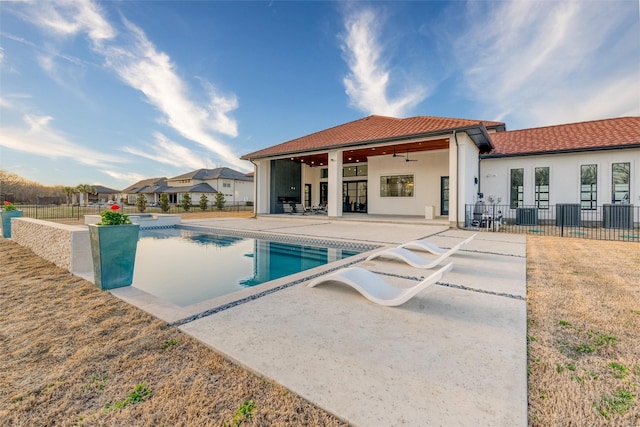 view of pool with a ceiling fan, a patio area, fence, and a pool with connected hot tub