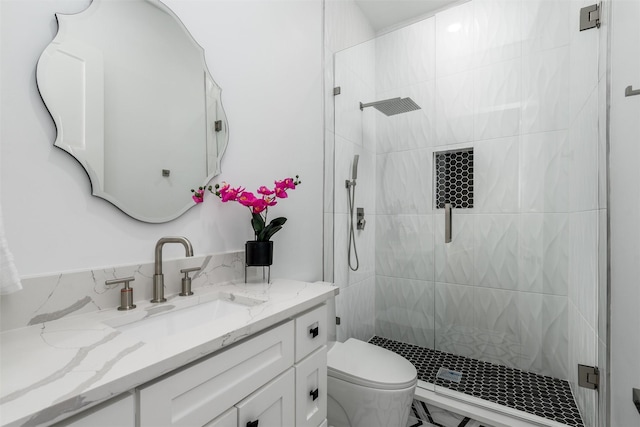 bathroom with a stall shower, toilet, and vanity