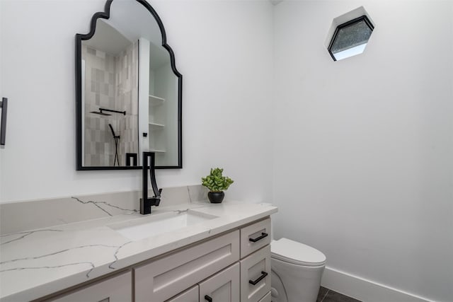 full bath with baseboards, toilet, a tile shower, tile patterned floors, and vanity