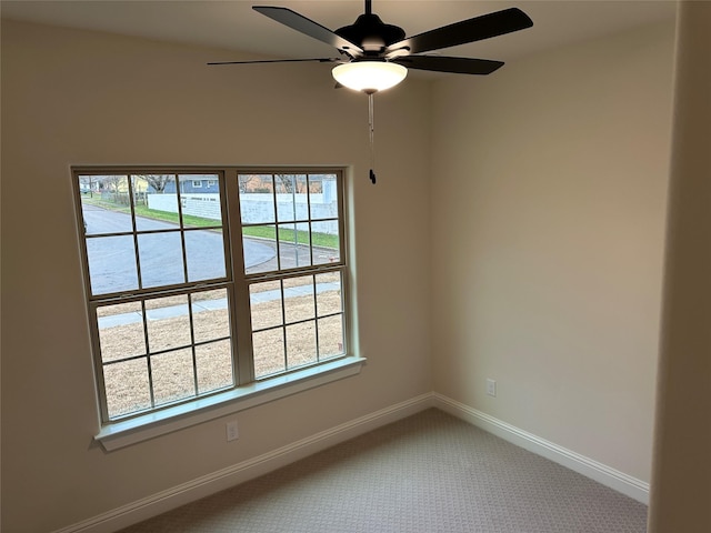 unfurnished room featuring carpet, a ceiling fan, and baseboards