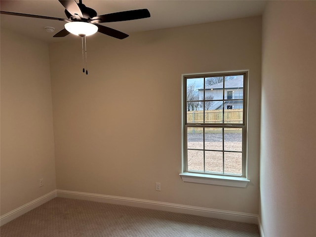 empty room with ceiling fan, carpet floors, and baseboards