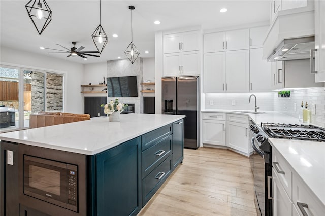 kitchen with stainless steel fridge with ice dispenser, built in microwave, a sink, gas range oven, and white cabinetry