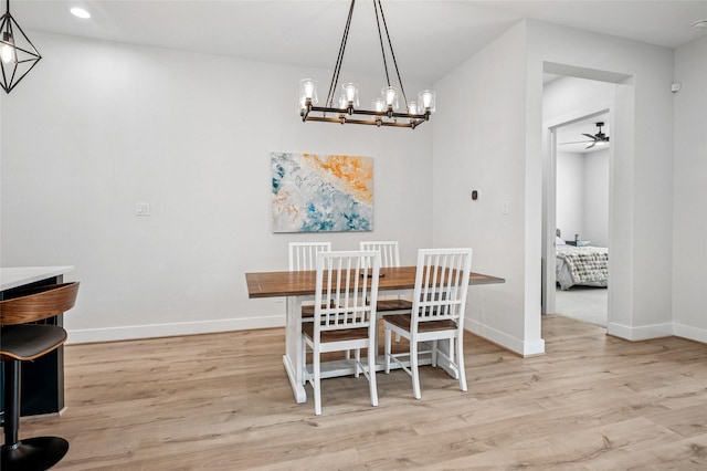 dining room with recessed lighting, light wood-style flooring, ceiling fan with notable chandelier, and baseboards