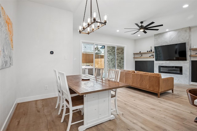 dining space featuring recessed lighting, baseboards, light wood-style floors, and a tiled fireplace