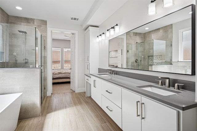 bathroom with visible vents, a shower stall, and a sink