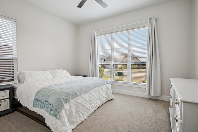 bedroom featuring baseboards, light carpet, and ceiling fan