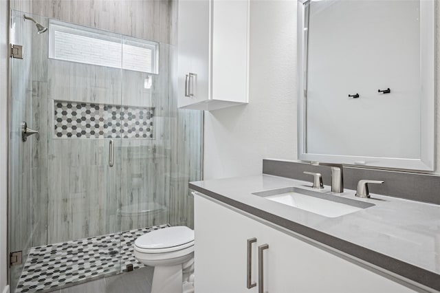 bathroom featuring vanity, toilet, and a shower stall