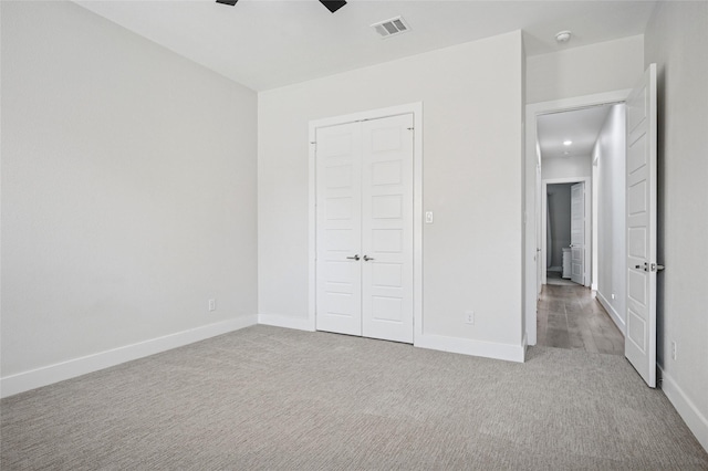 unfurnished bedroom featuring a ceiling fan, baseboards, visible vents, carpet floors, and a closet