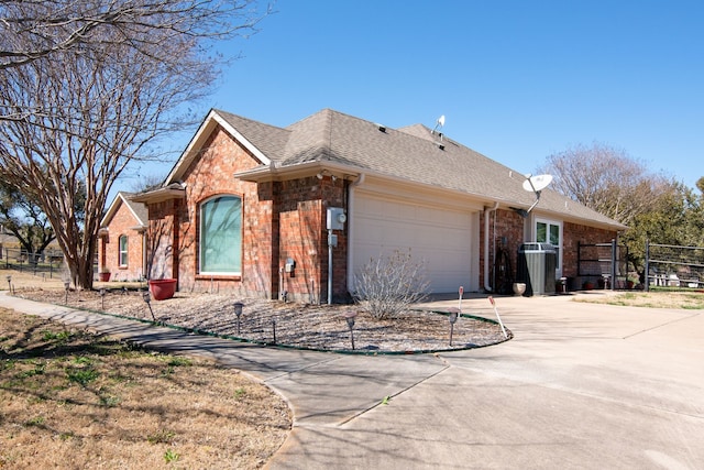 view of front facade featuring brick siding, an attached garage, concrete driveway, and roof with shingles