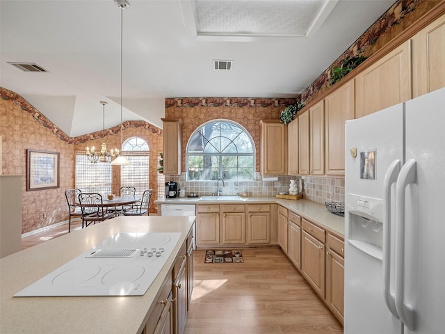 kitchen with white appliances, visible vents, light countertops, light brown cabinetry, and a sink