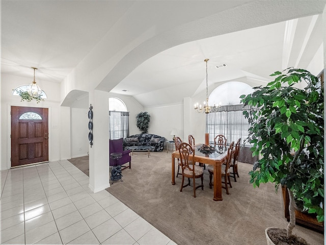 carpeted dining space featuring lofted ceiling, arched walkways, visible vents, tile patterned floors, and an inviting chandelier