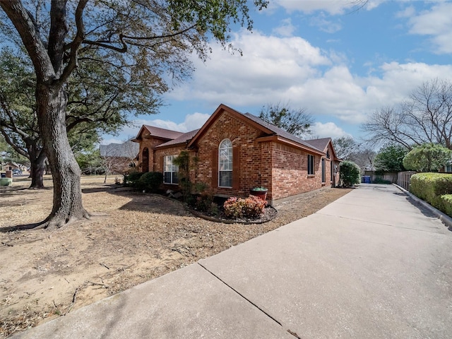 view of property exterior featuring brick siding and driveway