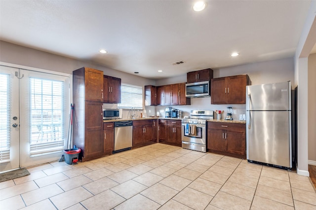 kitchen with visible vents, appliances with stainless steel finishes, light countertops, a sink, and light tile patterned flooring