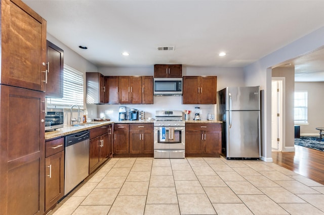 kitchen featuring a healthy amount of sunlight, visible vents, stainless steel appliances, and a sink