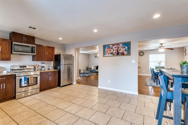 kitchen with stainless steel appliances, recessed lighting, visible vents, ceiling fan, and baseboards