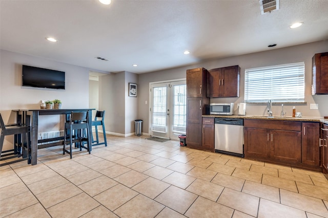 kitchen featuring light tile patterned floors, appliances with stainless steel finishes, a sink, and visible vents