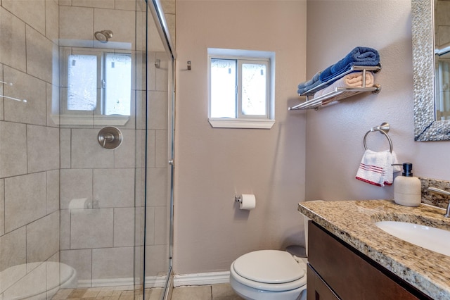 bathroom with baseboards, a shower stall, toilet, and vanity