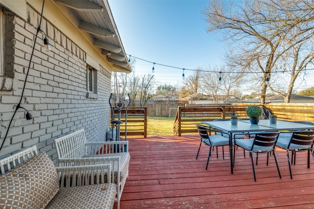 wooden terrace featuring a fenced backyard and outdoor dining area