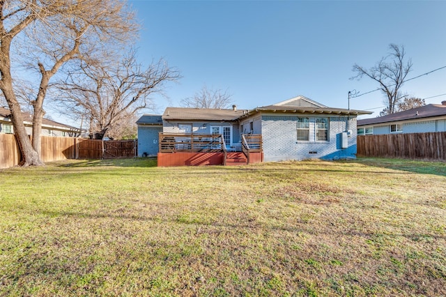 rear view of property featuring a wooden deck, a fenced backyard, crawl space, a yard, and brick siding