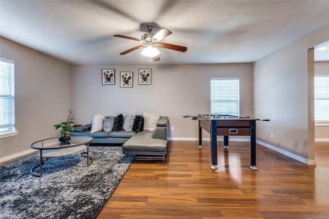 living room with ceiling fan, wood finished floors, and baseboards