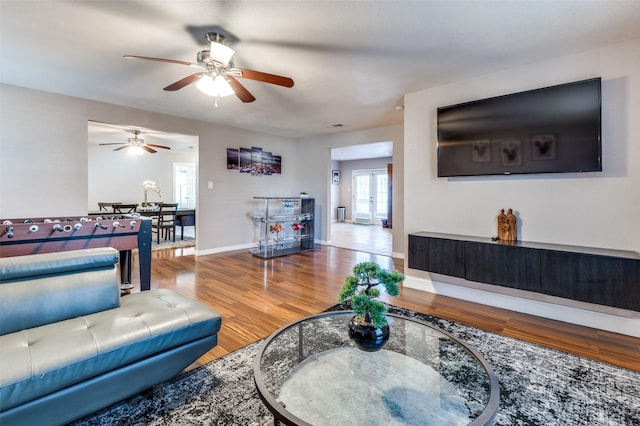 living room with french doors, wood finished floors, and baseboards