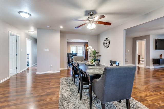 dining space featuring a ceiling fan, baseboards, and wood finished floors