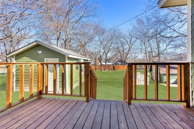 deck with an outbuilding, a lawn, and fence