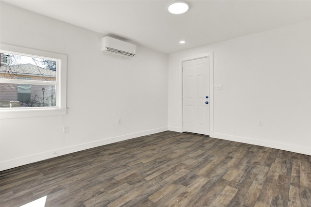 unfurnished room featuring dark wood-style floors, recessed lighting, a wall unit AC, and baseboards