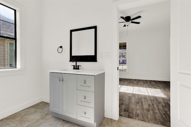 bathroom featuring ceiling fan, wood finished floors, vanity, and baseboards