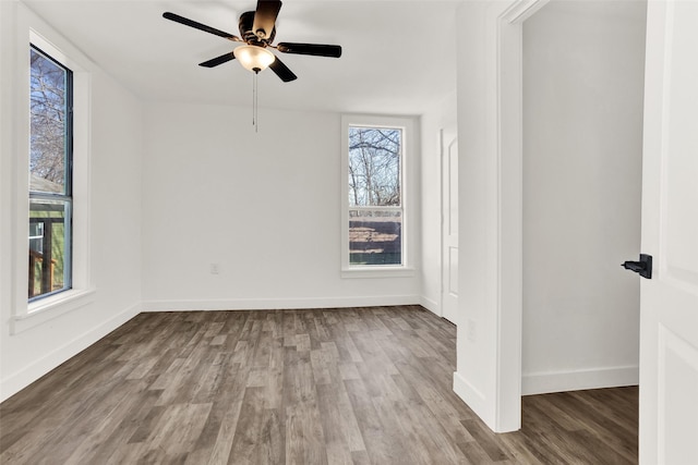 unfurnished room with a ceiling fan, baseboards, and wood finished floors