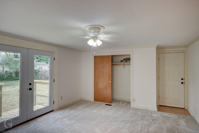 unfurnished bedroom featuring baseboards, light colored carpet, access to exterior, crown molding, and french doors