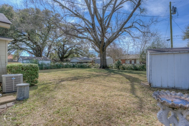 view of yard with an outbuilding, central AC, and a storage unit