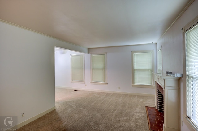 unfurnished living room featuring plenty of natural light, carpet floors, a fireplace, and baseboards