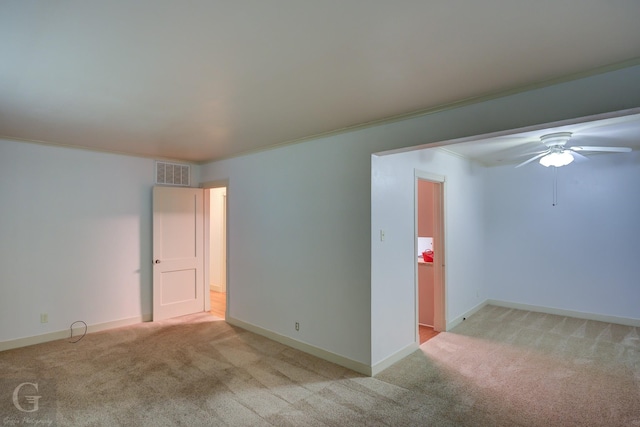 empty room featuring light carpet, baseboards, visible vents, and crown molding