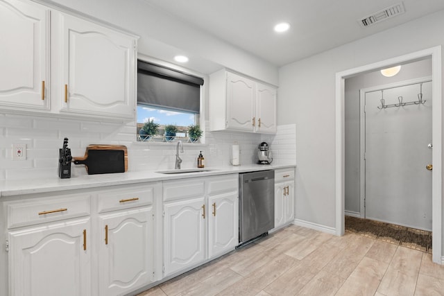 kitchen featuring a sink, visible vents, white cabinetry, light wood-type flooring, and dishwasher