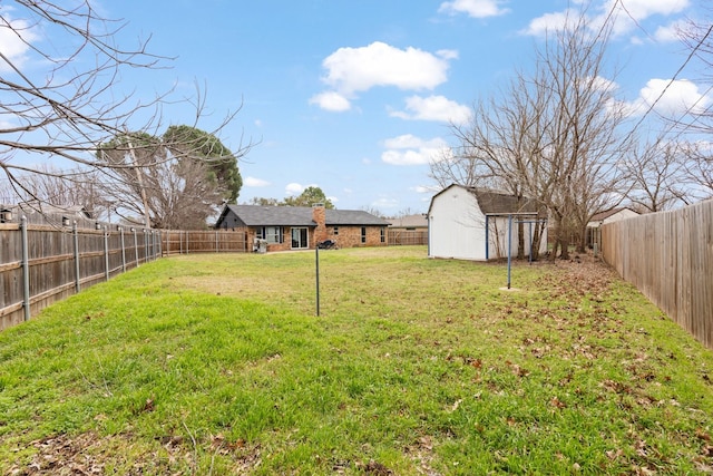 view of yard with a shed, an outdoor structure, and a fenced backyard