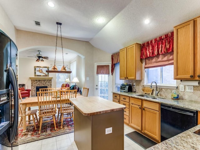 3605 Kales Ln, Flower Mound, TX 75022 - kitchen featuring a center island, tasteful backsplash, a sink, light tile patterned floors, and black appliances