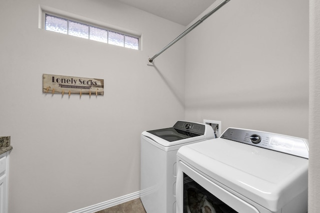 washroom with washing machine and dryer and baseboards