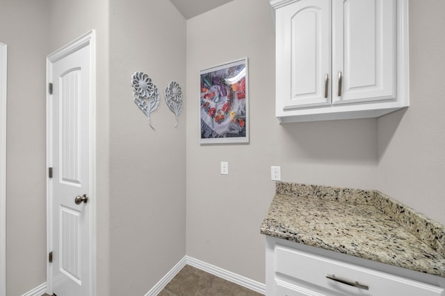 clothes washing area with baseboards