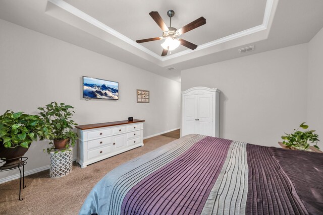 bedroom with carpet, visible vents, a tray ceiling, and baseboards