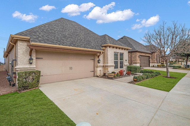 french country home featuring roof with shingles, a garage, stone siding, driveway, and a front lawn