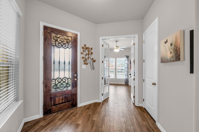 foyer with dark wood-type flooring and baseboards