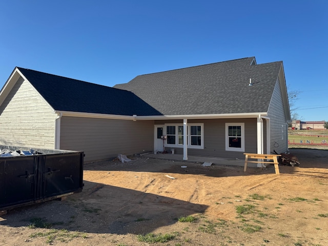 rear view of house with roof with shingles