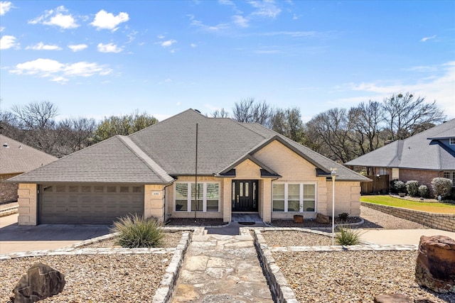 view of front of property with an attached garage, brick siding, driveway, and a shingled roof