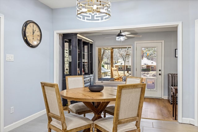 dining room featuring light wood-style floors, baseboards, and ceiling fan