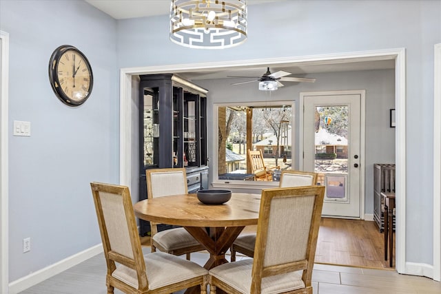4105 Cimmaron Trl, Granbury, TX 76049 - dining room featuring a chandelier, a ceiling fan, baseboards, and light wood-style floors