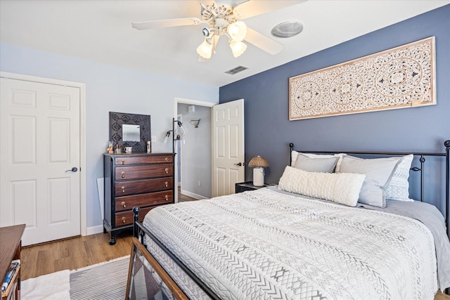 bedroom with visible vents, ceiling fan, baseboards, and wood finished floors